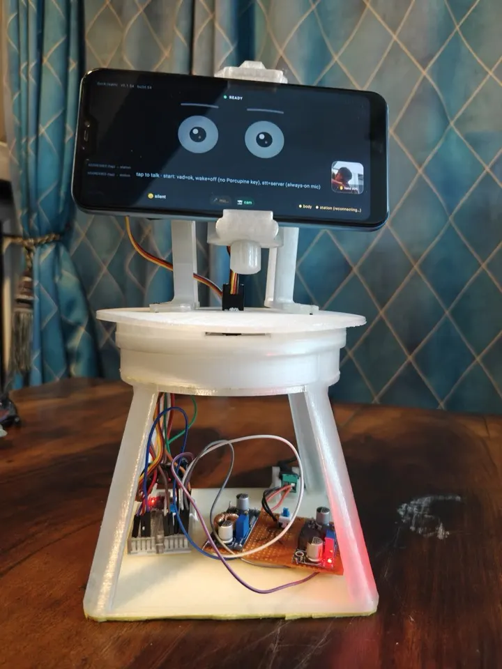 The orbit desk companion: an Android phone showing two cartoon eyes, held by servos on a 3D-printed base with its electronics visible